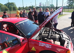 Powiększ zdjęcie. W Węgrowie kierowca rajdowy prezentuje uczniom swoje auto