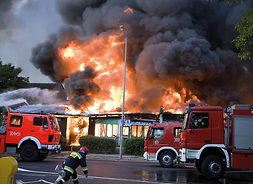 Zastępy straży pożarnej w akcji gaszenia płonącego budynku