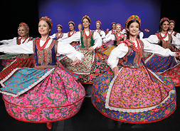 tancerze wirują na scenie w kolorowych strojach regionalnych