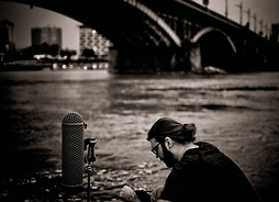 Tomek Mirt siedzi nad rzekę przy moście