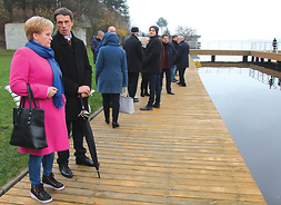 Goście kongresu stoją na drewnianym pomoście nad brzegiem zalewu zegrzyńskiego