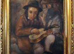 obraz w złotej ramie przedstawia grającego chłopaka na instrumencie
