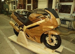Model naturalnej wielkości motocykla wyścigowego w całości zrobiony z różnych kawałków drewna