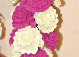 Zbliżenie na fragment splecionych dwukolorowych kwiatów o skomplikowanych płatkach z papieru