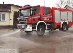 wóz strażacki z włączoną pompą wodną