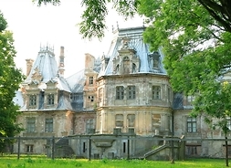 Widok na pałac pośród drzew, dwupiętrowy, z metalowym dachem