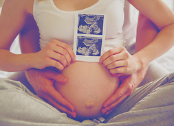Kobieta w zaawansowanej ciąży pokazuje wydruk z usg