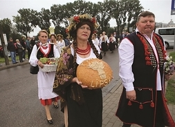 Przedstawiciele powiatu lipskiego w strojach ludowych nosią chleb dożynkowy