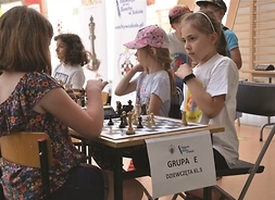 przy stoliku z szachami siedzą dwie dziewczynki