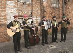 mężczyźni z instrumentami stoją w szeregu