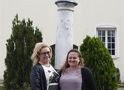 dwie kobiety stoją przy pomniku