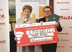 Elżbieta Lanc i dyrektorka szpitala trzymają symboliczny czek na unijne dofinansowanie