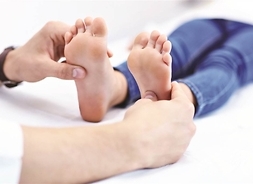 stopy dziecka bada dorosły (widok na stopy i dłonie)