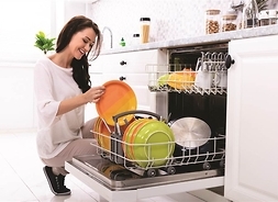 kobieta wkłada naczynia do zmywarki