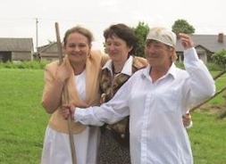 trzy kobiety stoją na trawie