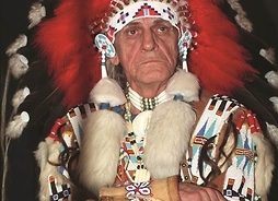 Zdjęcie mężczyzny w stroju indiańskim, z pióropuszem na głowie