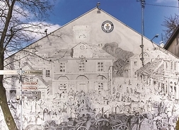 Elewacja budynku z rysunkiem wykonanym ołówkiem przedstawiającym grójecki rynek.