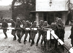 Żołnierze przełamujący szlaban graniczny. Zdjęcie archiwalne