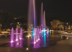 podświetlane fontanny na placu w mieście w nocy