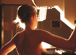 Kobieta odwrócona plecami, podczas wykonywania mammografii.