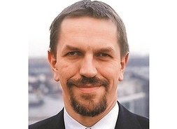 Profesor Jarosław Flis - zdjęcie portretowe uśmiechniętego mężczyzny z zarostem.