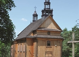 drewniany kościół, na pierwszym planie ogrodzenie