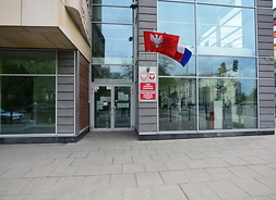 wejście do budynku urzędu marszałkowskiego, na fasadzie wisi m.in. flaga województwa mazowieckiego
