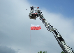 Flaga Polski wciągana na „maszt” na wysięgniku wozu strażackiego
