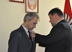 Wicewojewoda Dariusz Piątek wręcza medal Bogumiłowi Feduniewiczowi