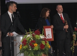 Na scenie wicemarszałek Janina Ewa Orzełowska, członek zarządu Wiesław Raboszuk oraz prowadzący Tomasz Kammel