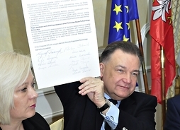 Marszałek Adam Struzik trzyma w ręku podpisaną umowę partnerstwa