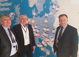 Marszałkowie Sosnowski, Struzik oraz Stępień przy mapie inicjatyw władz lokalnych i regionalnych w Europejskim Komitecie Regionów pozują do zdjęcia
