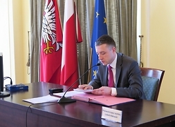 Przewodniczący sejmiku Ludwik Rakowski siedzi przy stole prezydialnym