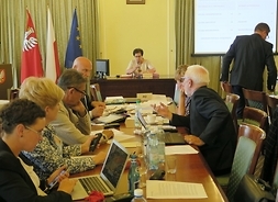Radni Klubu Platformy Obywatelskiej siedzą przy stole, w tle przy stole prezydialnym wiceprzewodnicząca sejmiku Wiesława Krawczyk