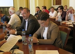 Przy stole siedzą radni Klubów Platformy Obywatelskiej i Polskiego Stronnictwa Ludowego