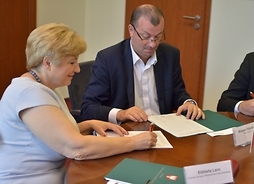 Wicemarszałek Wiesłąw Raboszuk i członek zarządu Elżbieta Lanc podpisują umowy