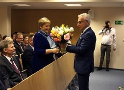 Elżbieta Lanc odbiera kwiaty od dyrektora spitala Wojciecha Miazgi