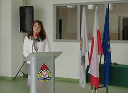 Za mównicą wicemarszałek Janina Ewa Orzełowska, obok sztandary i flagi