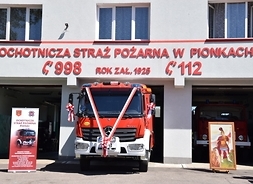 budynek OSP w Pionkach, obok nowy wóz strażacki