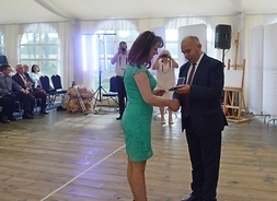 Janina Ewa Orzełowska odbiera medal pamiątkowy z rąk starosty siedleckiego Dariusza Stopy