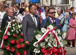 Marszałek i dyrektor Kominek z wieńcem w kolejce czekających na złożenie ich pod pomnikiem
