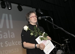 laureatka trzyma dyplom i różę