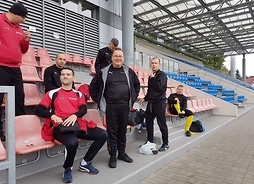 Reprezentanci Mazowsza siedzący na trybunach stadionu sportowego.