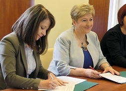 umowy na unijne dofinansowanie projektów podpisują, siedząc na stołem prezydialnym przedstawiciele samorzadu województwa i gminy Wołomin