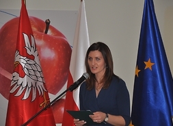 Justyna Niedzielak, kierownik Biura Współpracy i Promocji Gospodarczej stoi przed mównicą