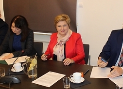 Wicemarszałek Janina Ewa Orzełowska składa podpisane egzemplarze umowy. Obok członek zarządu Elżbieta Lanc i Burmistrz Sokołowa podlaskiego Bogusław Karakula