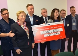 wicemarszałek Janina Ewa Orzełowska, członek zarządu Elżbieta Lanc i beneficjenci z symbolicznym czekiem w ręku