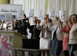 Kobiety trzymają kartki z literami układającymi się w słowo "Relaks"