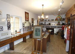 Zdjęcie przedstawia wnętrze sali muzeum. Prezentowane są regionalny strój, dawne meble i naczynia.