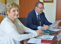 z umowami w ręku przy stole siedzą Wicemarszałek Wiesław Raboszuk i członek zarządu Elżbieta Lanc